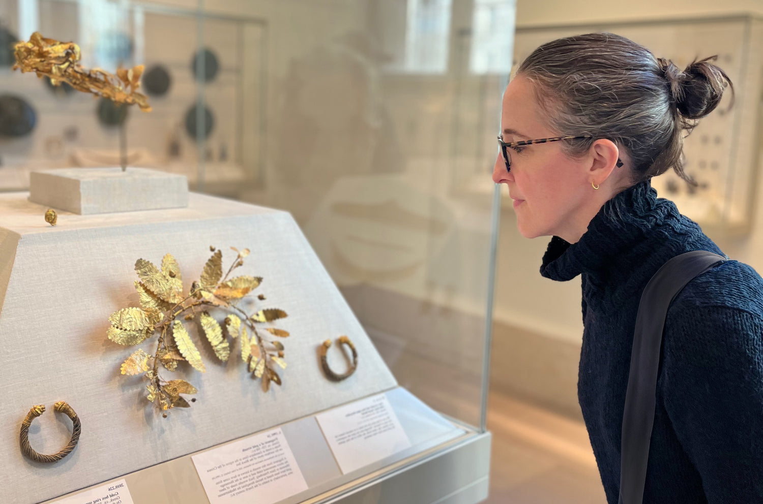 Alexis Menten studying ancient gold jewelry on exhibit at the Metropolitan Museum of Art