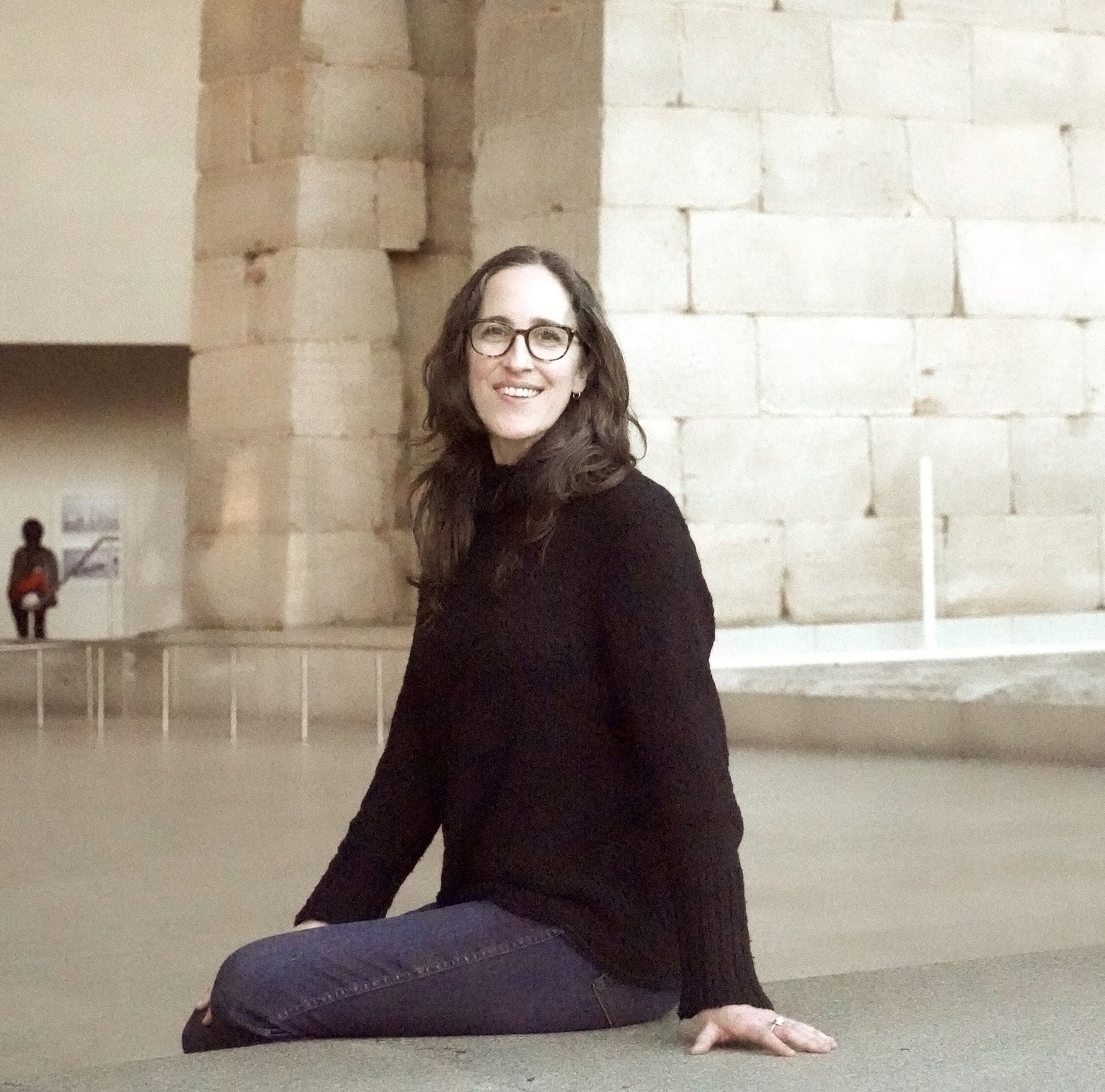 Alexis Menten sitting in front of the ancient Egyptian Temple of Dendur at the Metropolitan Museum of Art in New York City