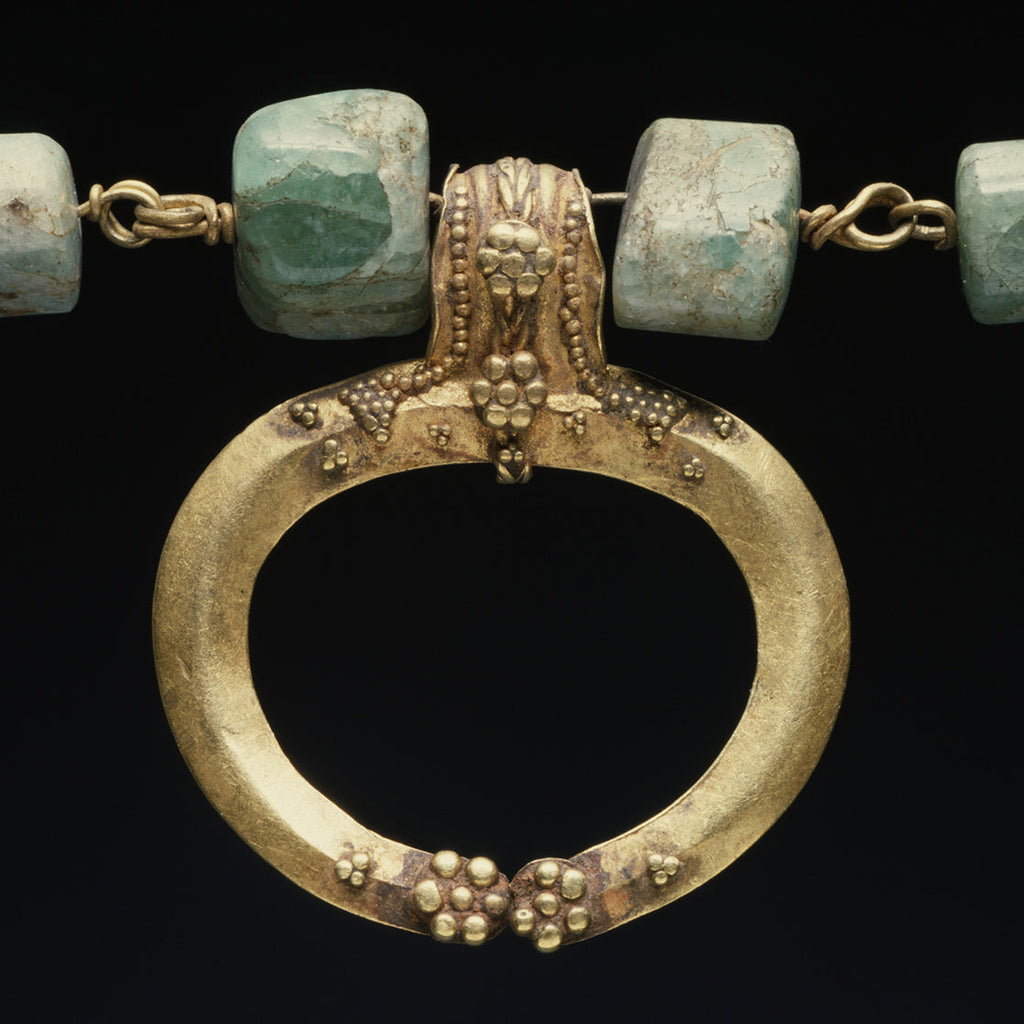 A gold crescent shaped pendant with granulation on a chain with green agate beads from ancient Rome in the Walters Art Museum