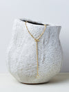 Ancilia Chain by Alexis Menten with handmade 20k gold figure eight ancient style links shown as a lariat on a ceramic vase