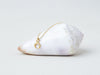 Lunula Necklace by Alexis Menten with a 22k gold crescent shaped pendant handmade in an ancient style shown on a seashell