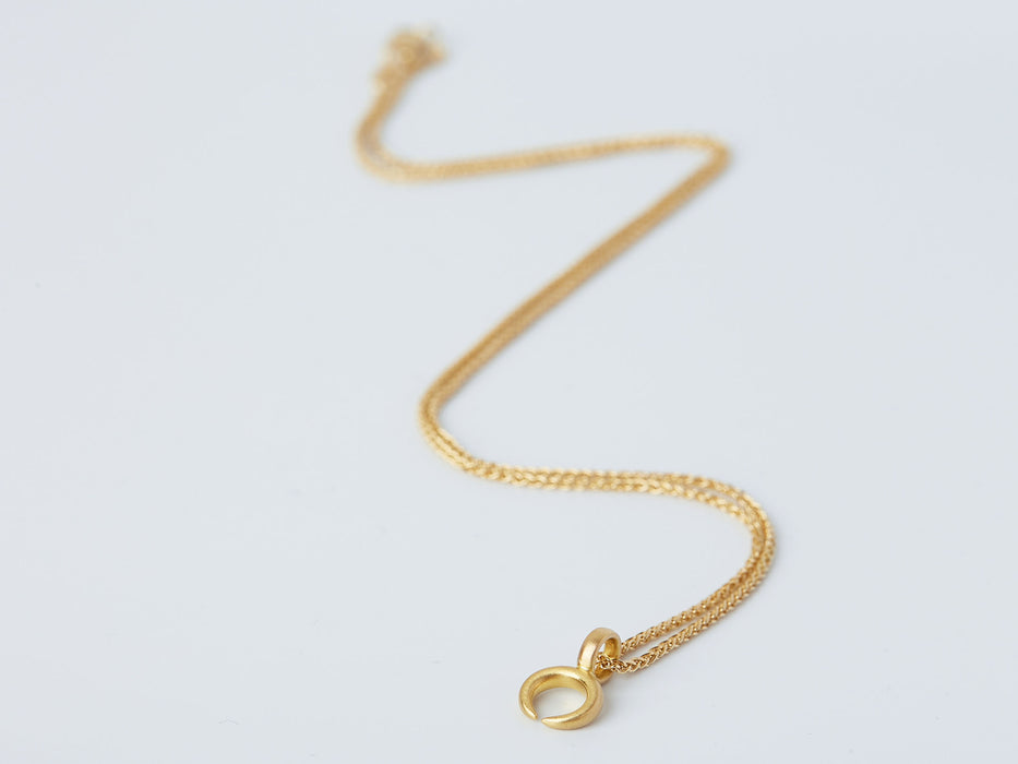 Lunula Necklace by Alexis Menten with a 22k gold crescent shaped pendant handmade in an ancient style shown from the side