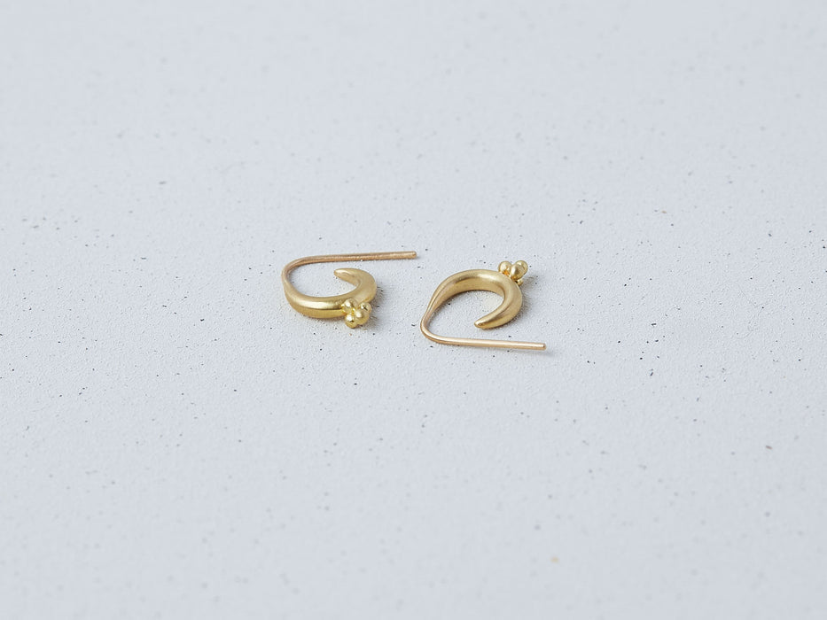 Mari Earrings handmade by Alexis Menten with 22k gold ancient style crescent hoops and granules shown lying on their sides