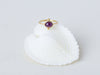 Satnal Ring by Alexis Menten handmade in an ancient style with 22k gold, a ruby, and two granules shown on a seashell