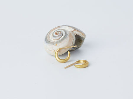 Selene Earrings by Alexis Menten with 22k gold crescent hoops handmade in an ancient style displayed next to a seashell