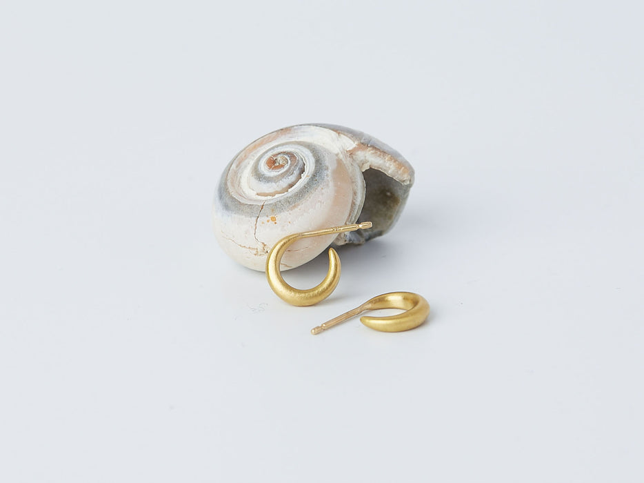 Selene Earrings by Alexis Menten with 22k gold crescent hoops handmade in an ancient style displayed next to a seashell