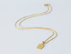 Stele Necklace by Alexis Menten with a rectangular 22k gold pendant handmade in an ancient style shown from the side