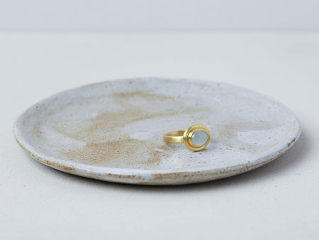 Thyra Ring by Alexis Menten handmade in an ancient style with 22k gold and aquamarine displayed on a ceramic dish