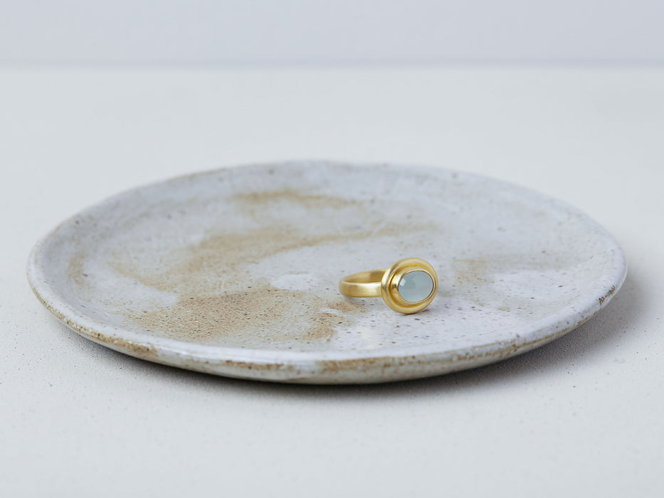 Thyra Ring by Alexis Menten handmade in an ancient style with 22k gold and aquamarine displayed on a ceramic dish