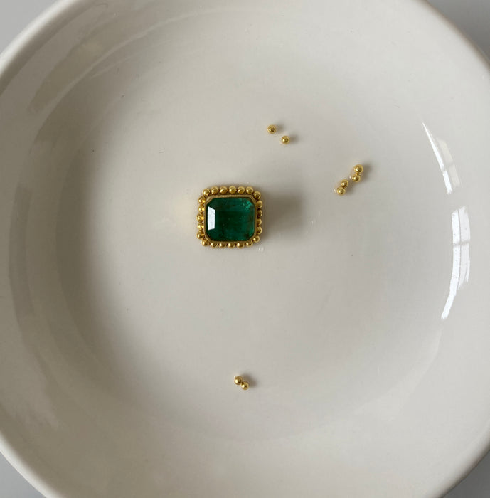 Ancient style 22k gold and emerald pendant by Alexis Menten surrounded by 22k gold granules ready to be placed