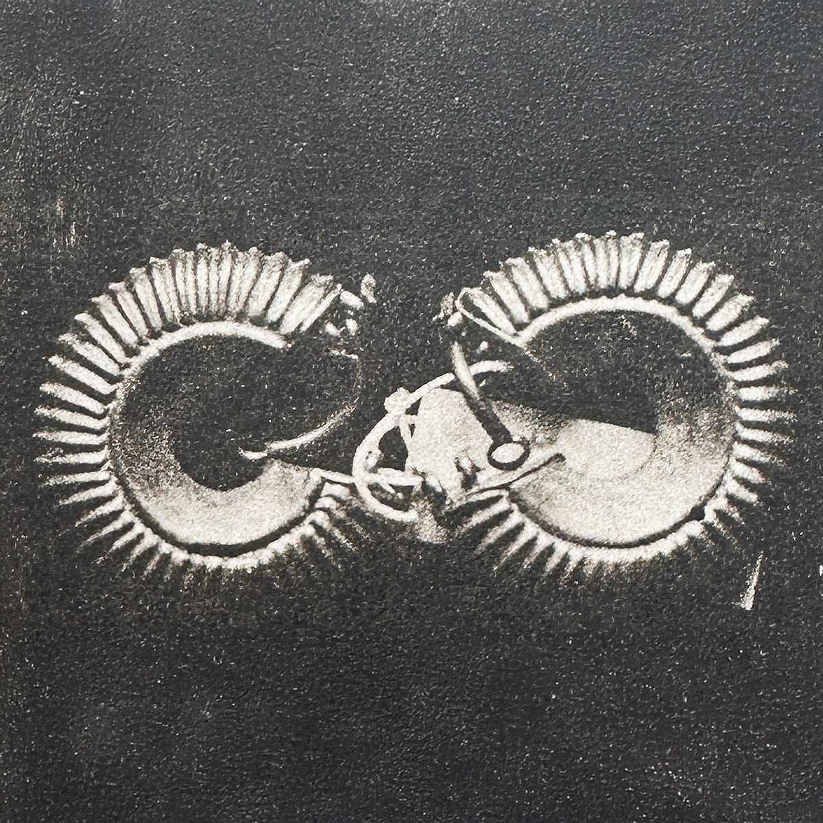 Black and white photo of two ancient Lydian hoop earrings with ear wires from Sardis